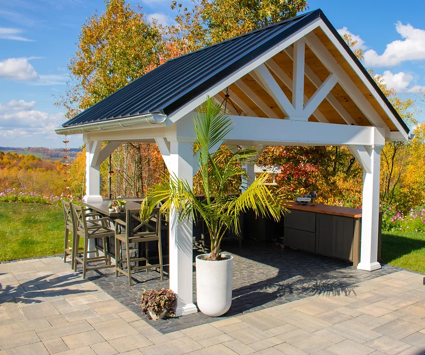 White backyard pavilion structures with patio seating and outdoor storage