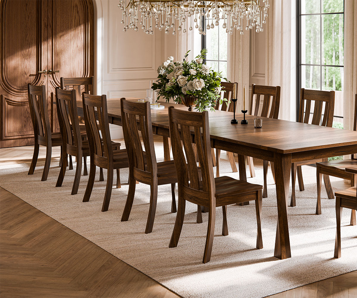 Hardwood dining table and chairs under crystal chandelier in bright dining room.