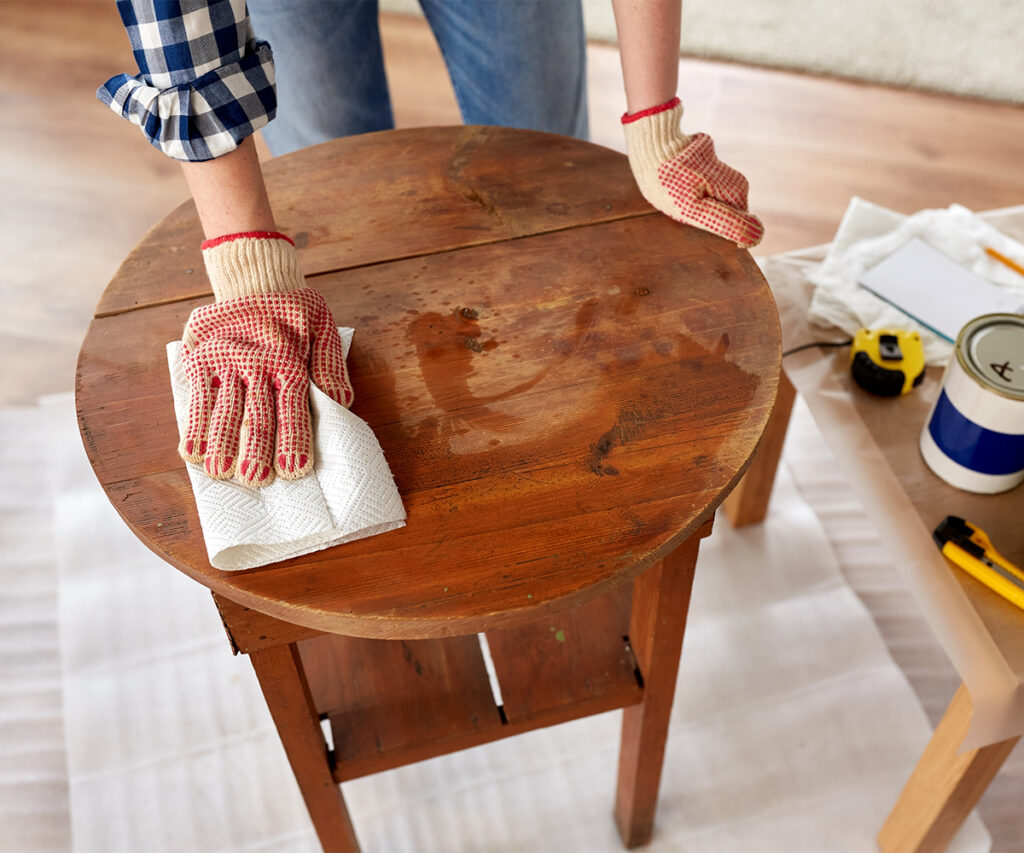 Wood care guide: polishing a round hardwood table with a soft cloth.