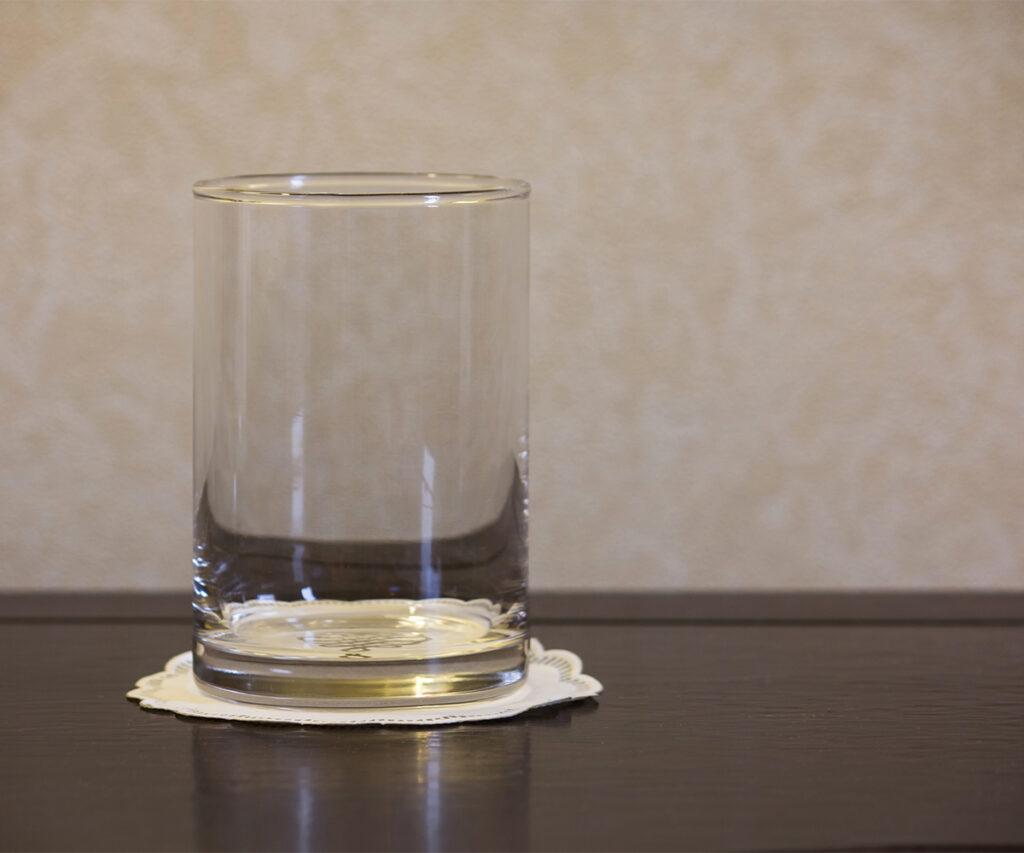Protecting wood furniture: glass on a coaster to prevent rings and water marks.