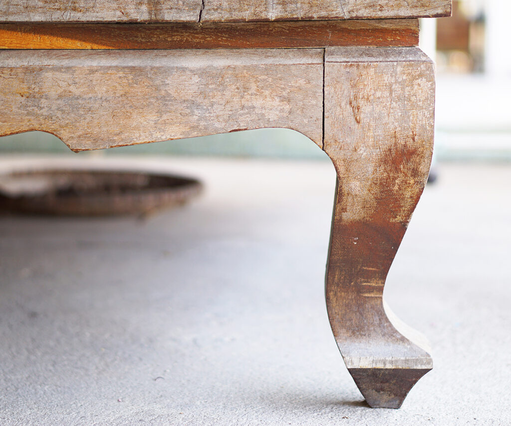 Wood care guide: faded table leg showing uneven finish ready for staining.